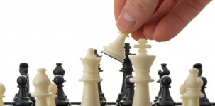 Pawn in hands over a chessboard
